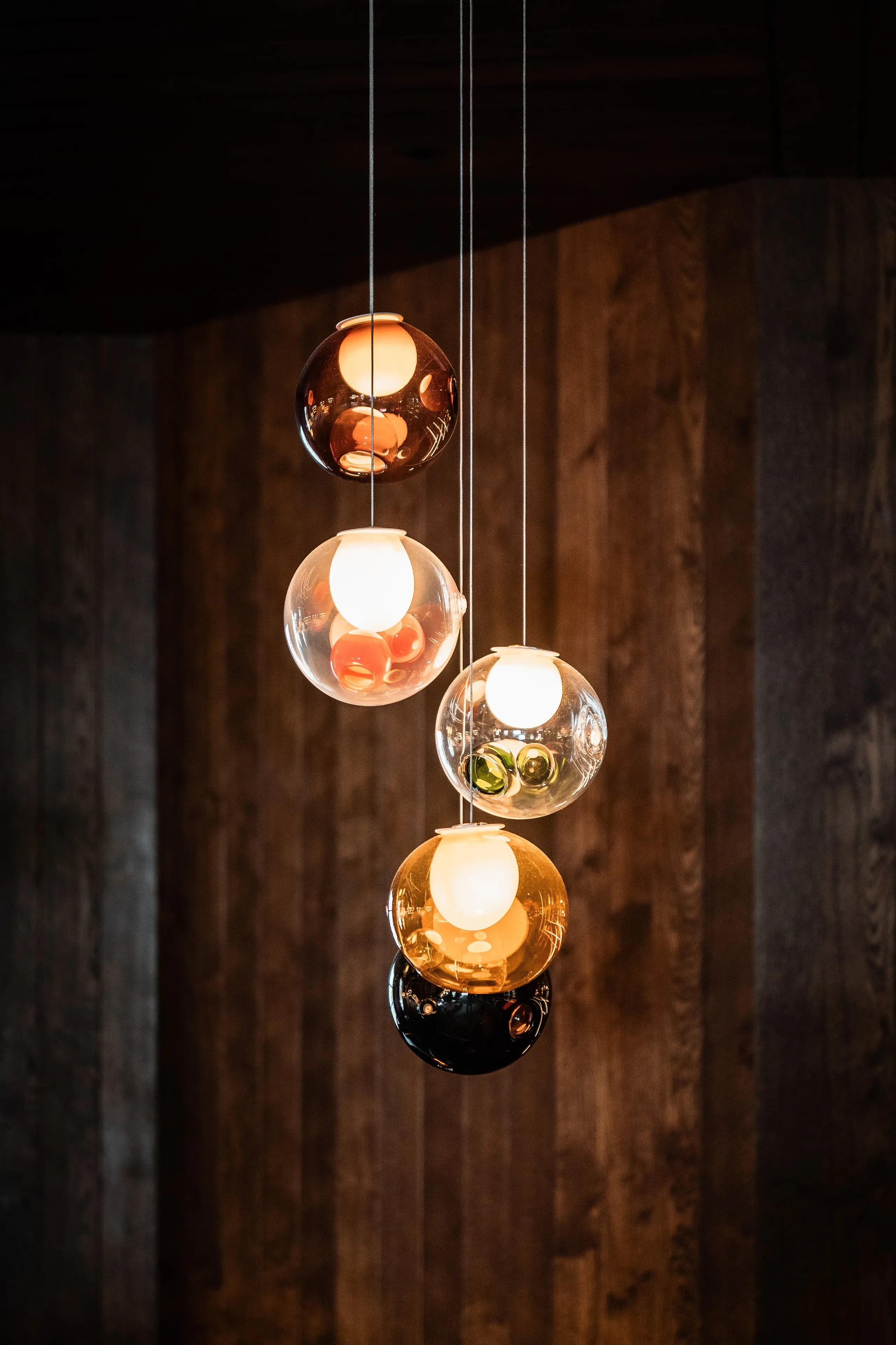 Suspension lumineuse design avec boules en verre coloré.