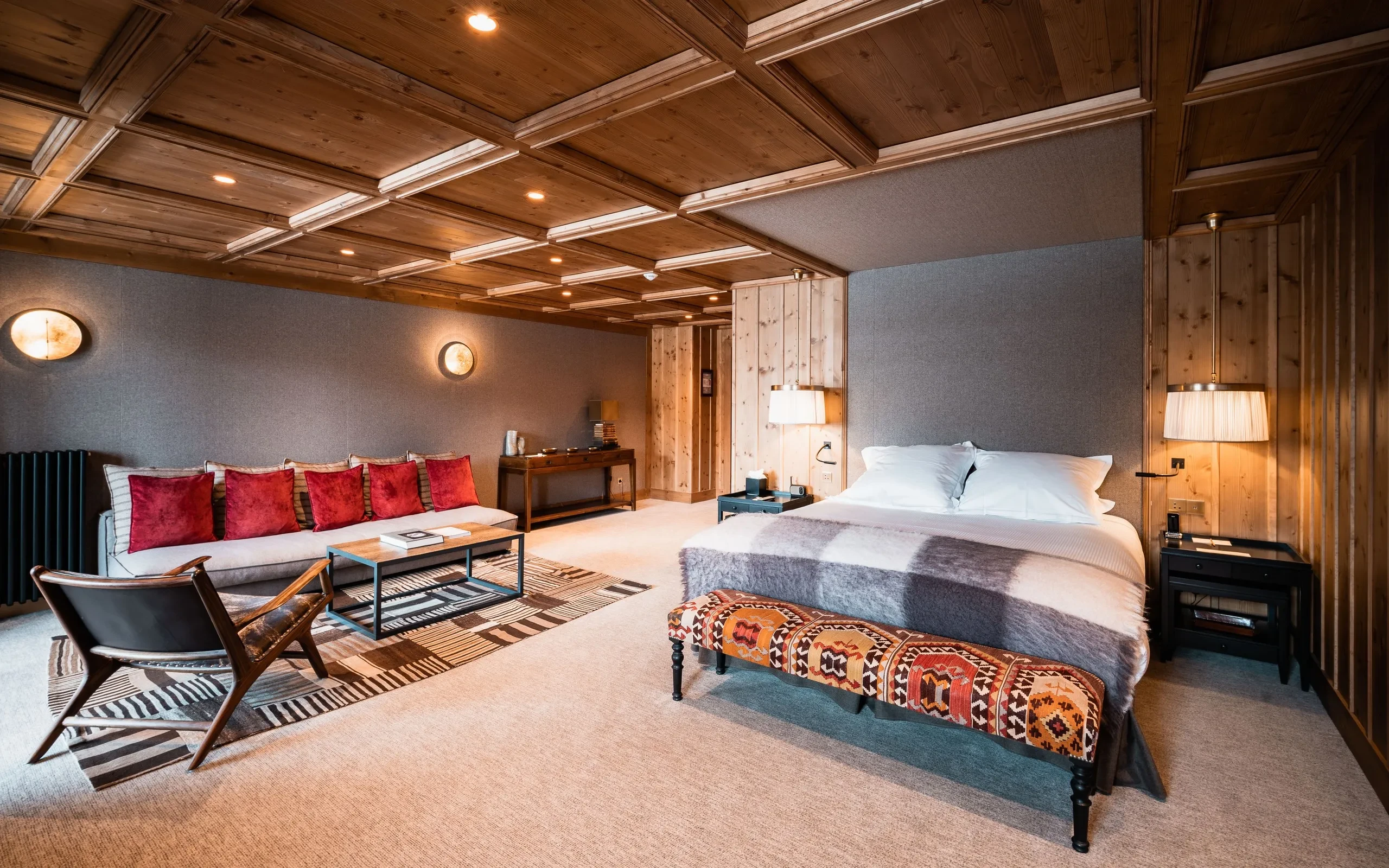 Chambre chaleureuse avec lit et canapé design, Hôtel de luxe La Mourra à Val d’Isèr