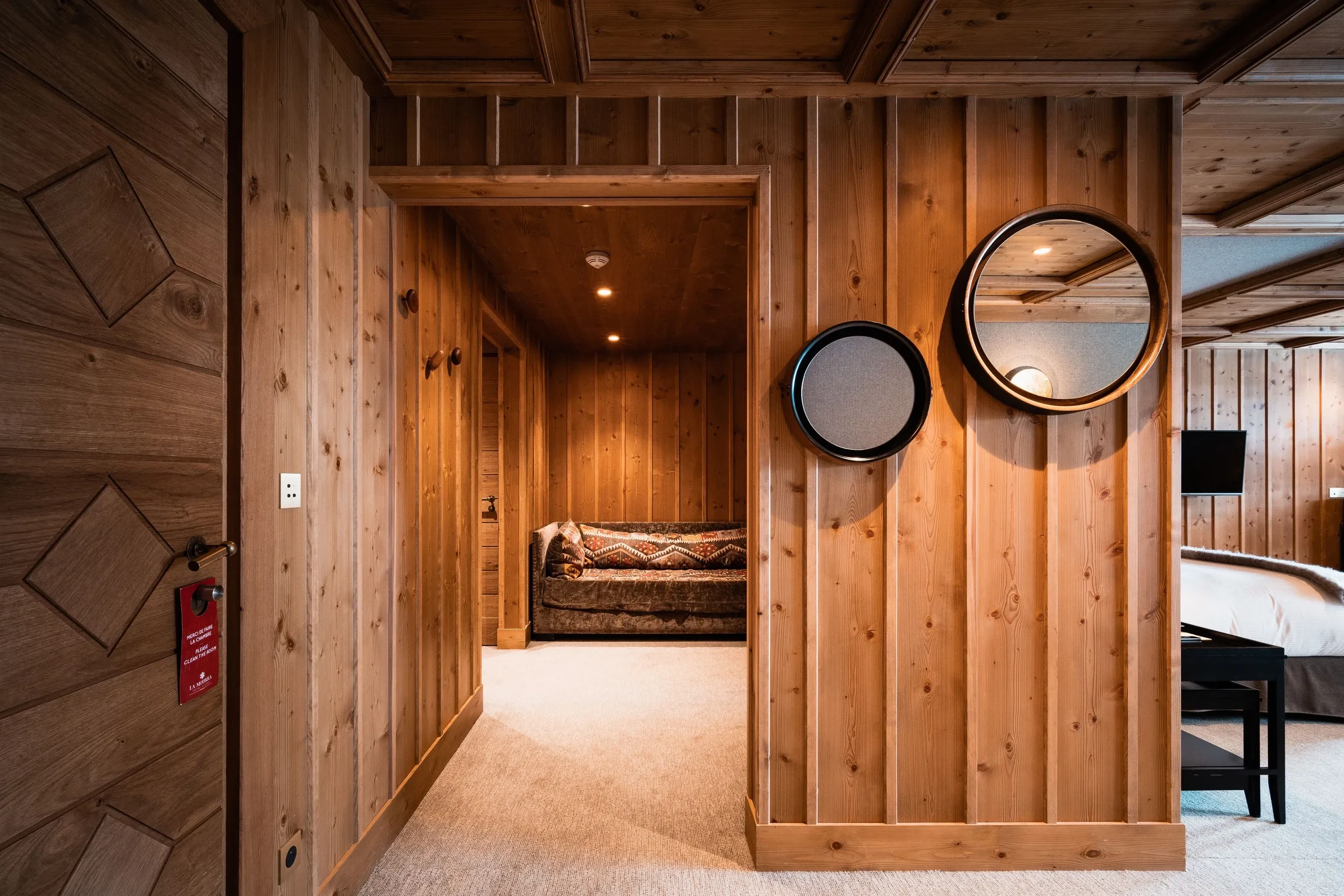 Chambre en bois avec miroir et canapé Hôtel de luxe La Mourra à Val d’Isèr