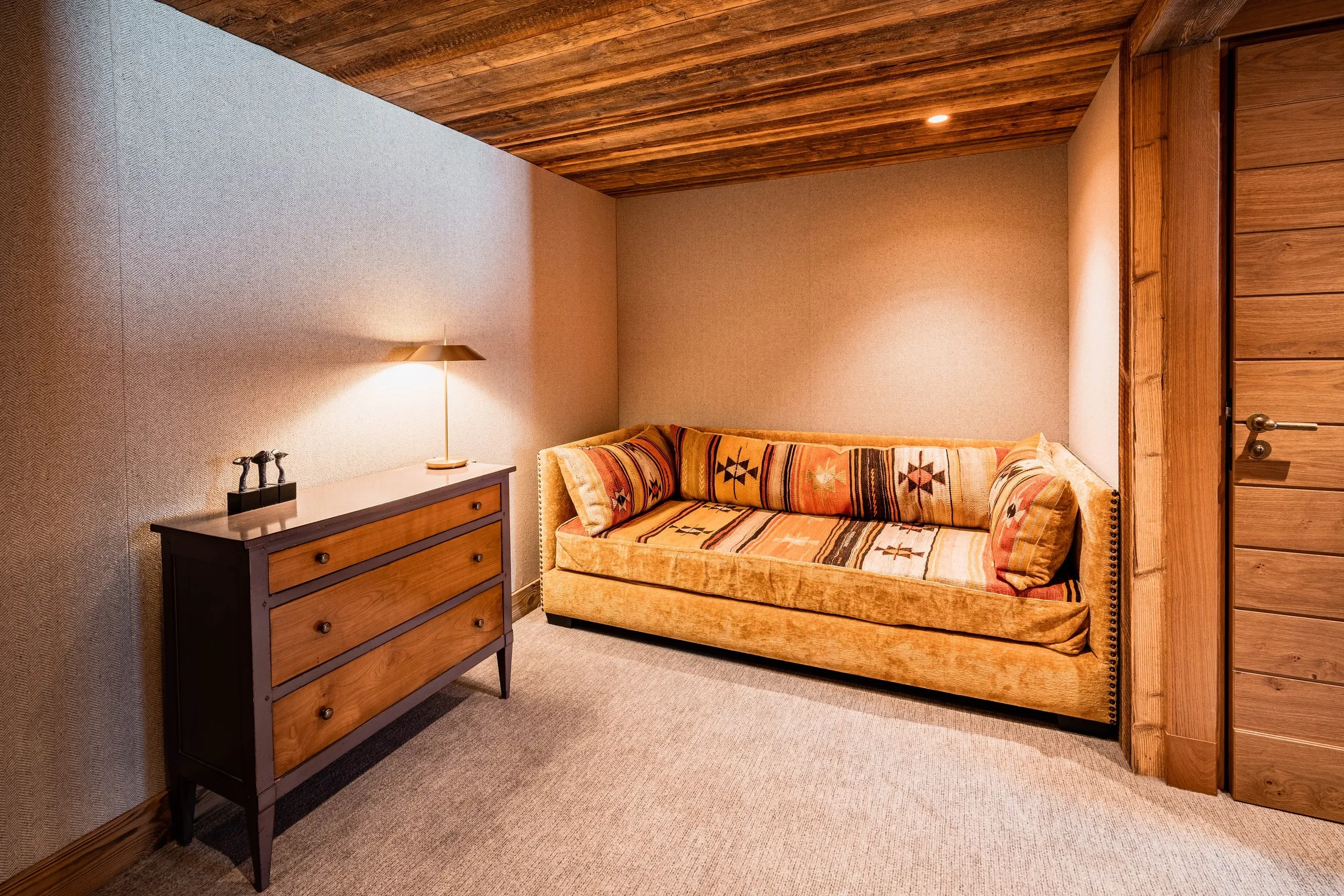 Salon rustique avec canapé et commode en bois, Hôtel de luxe La Mourra à Val d’Isèr