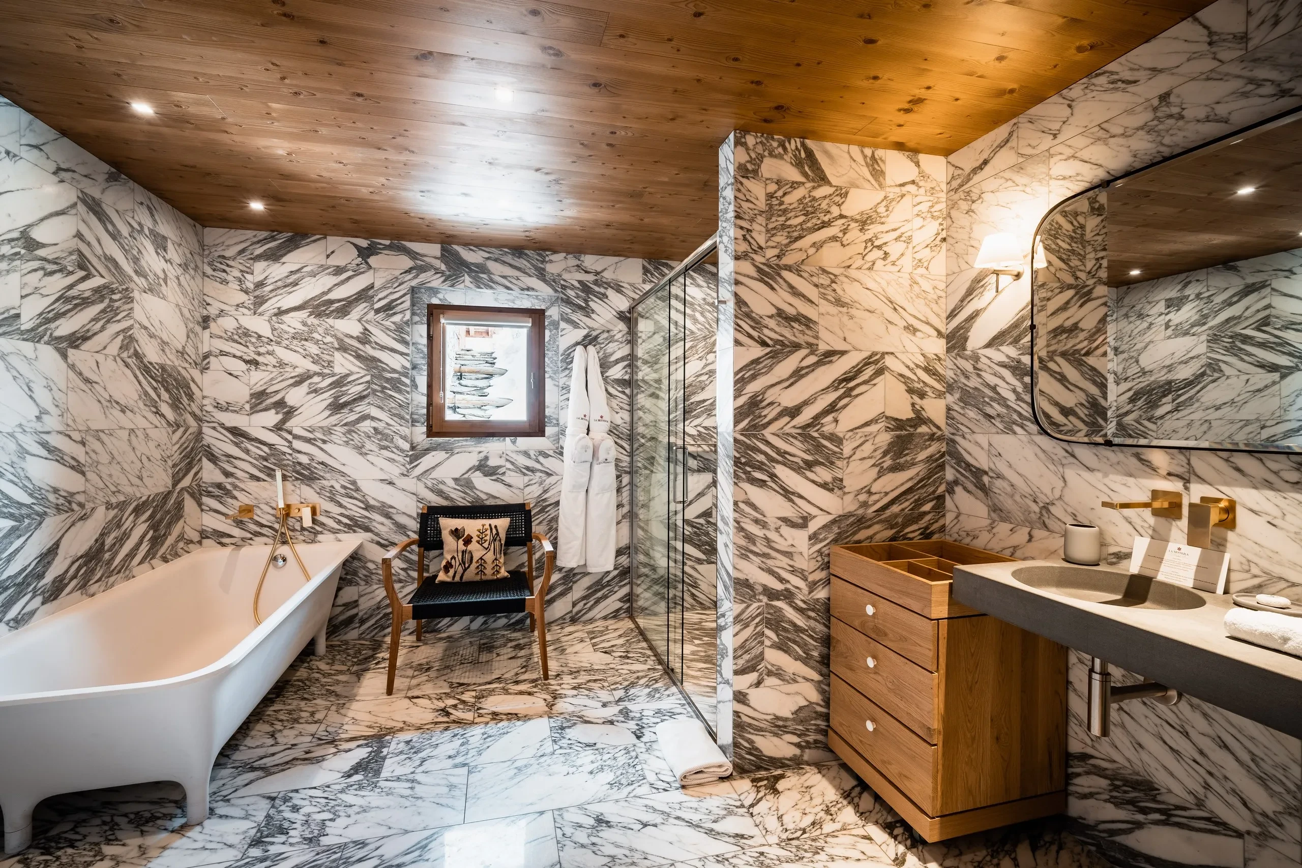 Salle de bain moderne avec marbre et bois, Hôtel de luxe La Mourra à Val d’Isèr