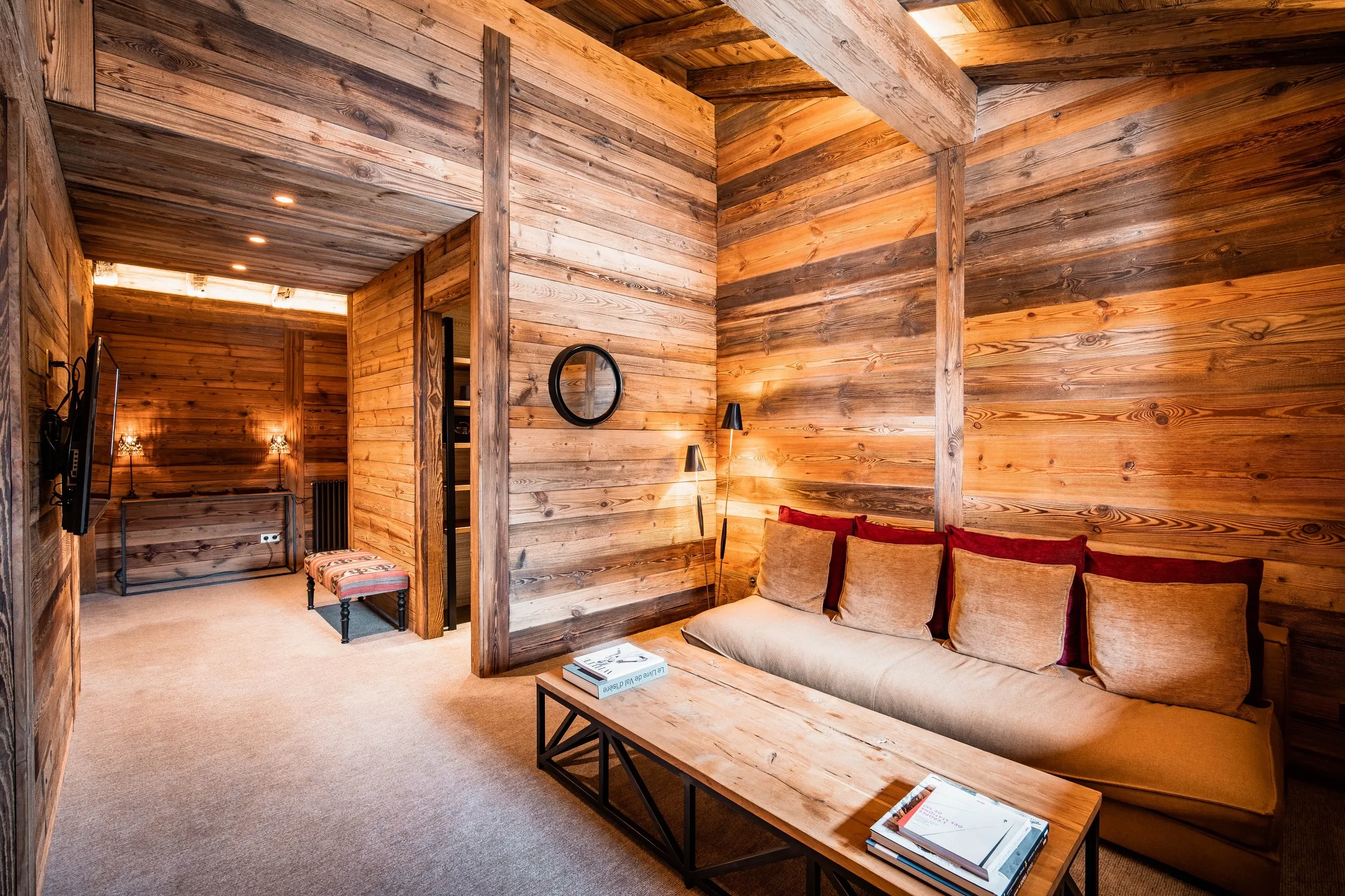 Salon chaleureux en bois avec canapé et table basse, Hôtel de luxe La Mourra à Val d’Isèr
