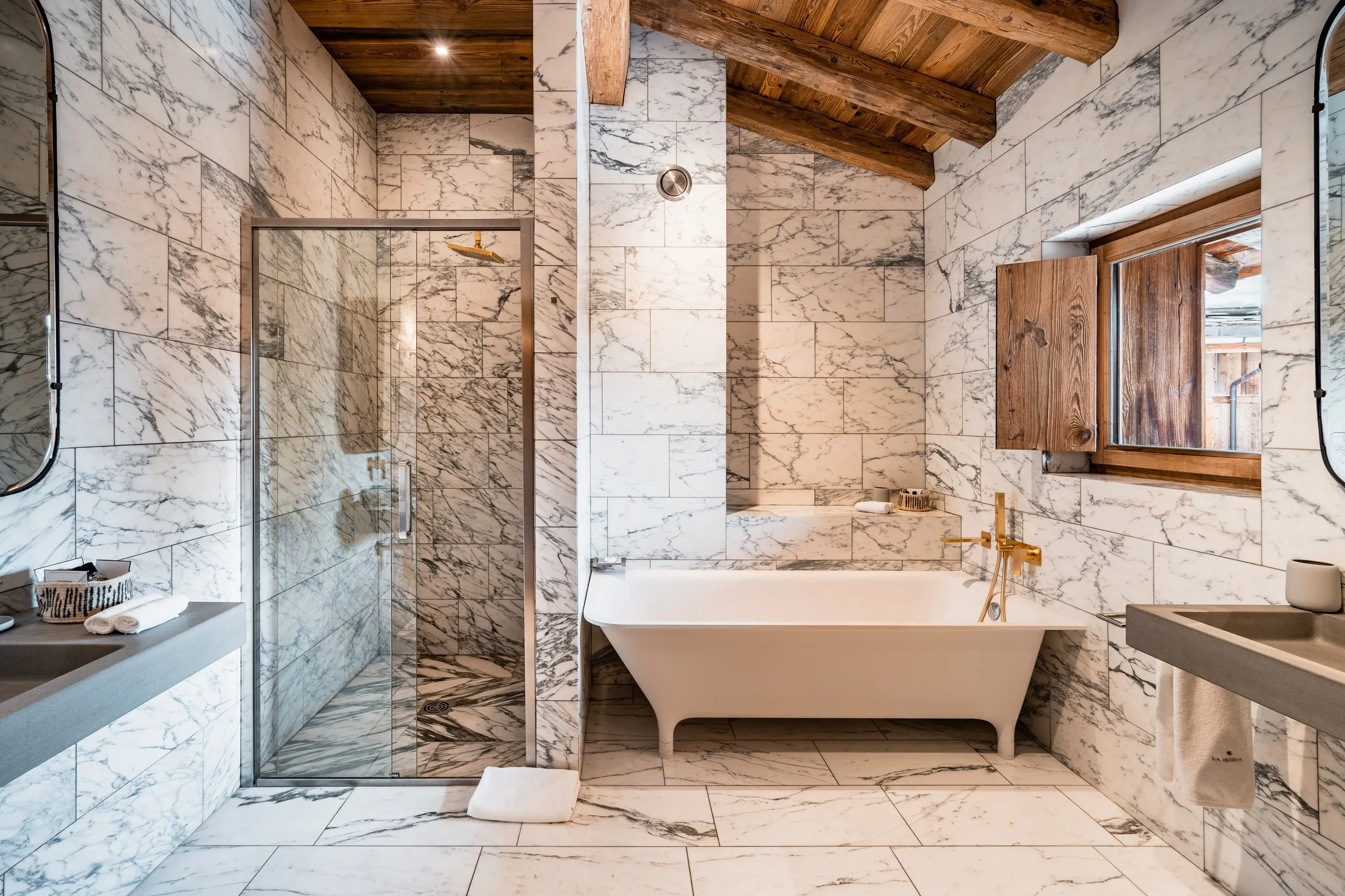 Salle de bain moderne avec marbre et bois, Hôtel de luxe La Mourra à Val d’Isèr