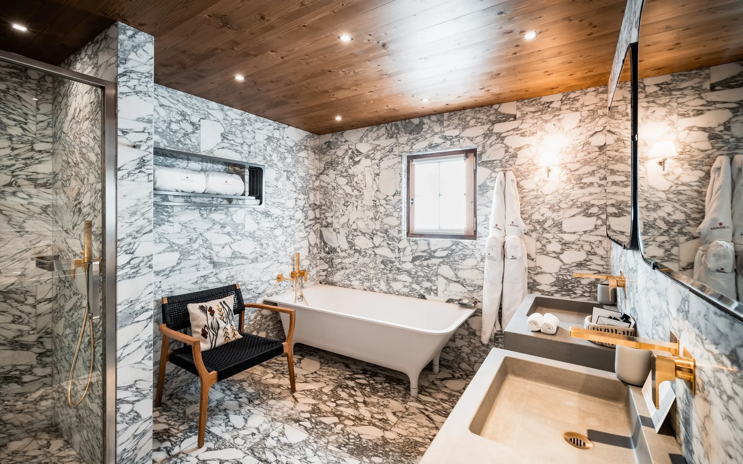 Salle de bain en marbre avec baignoire et lavabo, Hôtel de luxe La Mourra à Val d’Isère