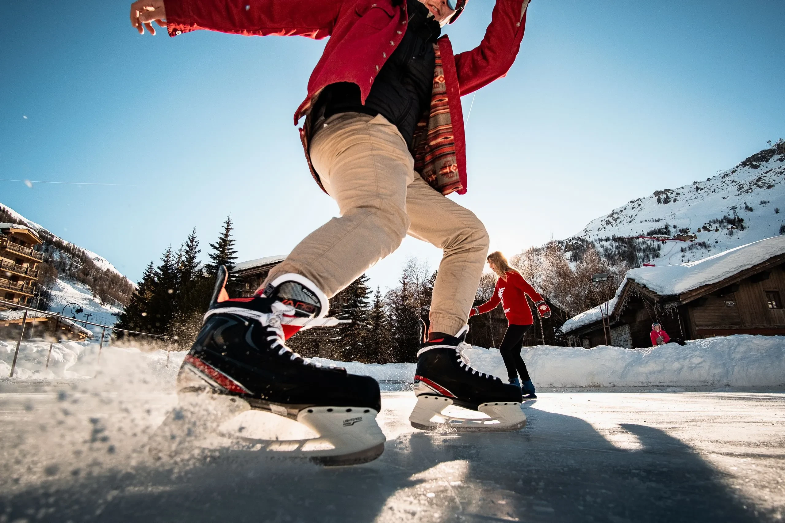 Personnes patinant sur glace en montagne ensoleillée, Hôtel à Val d’Isère avec piscine, La Mourra.
