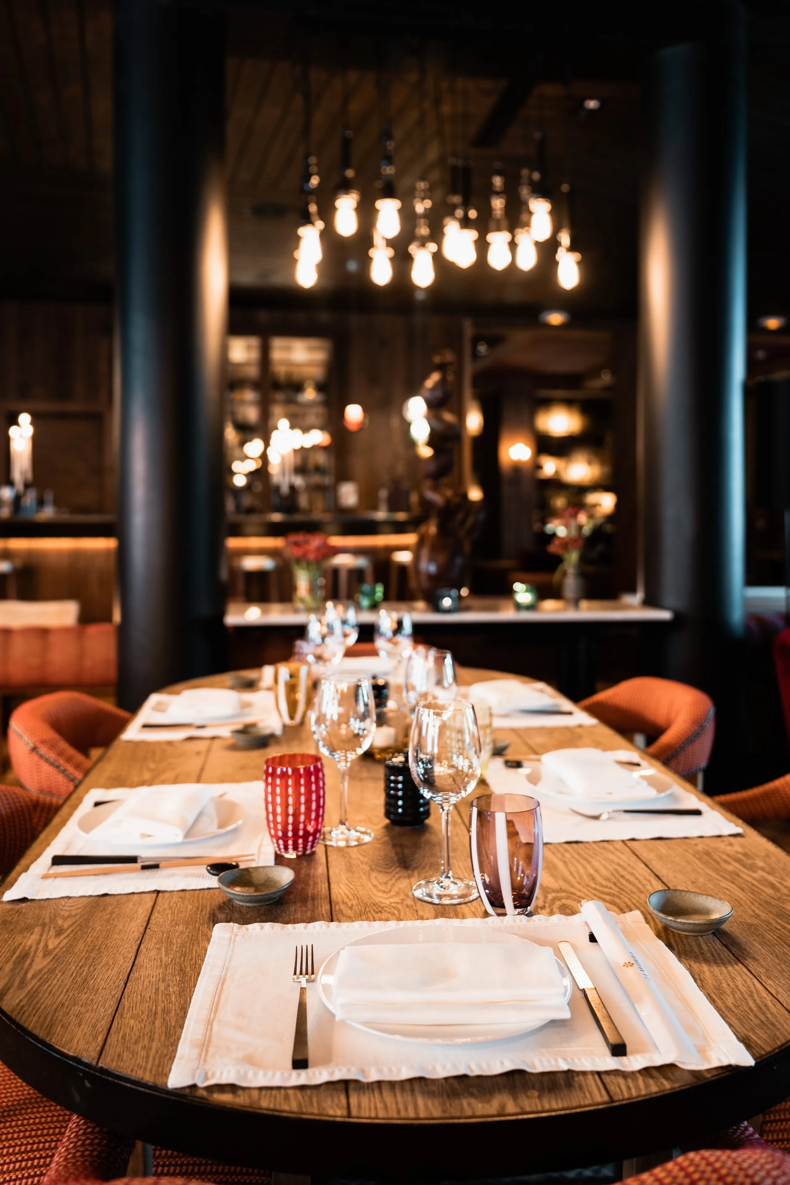 Table de restaurant élégamment dressée avec luminaires modernes.