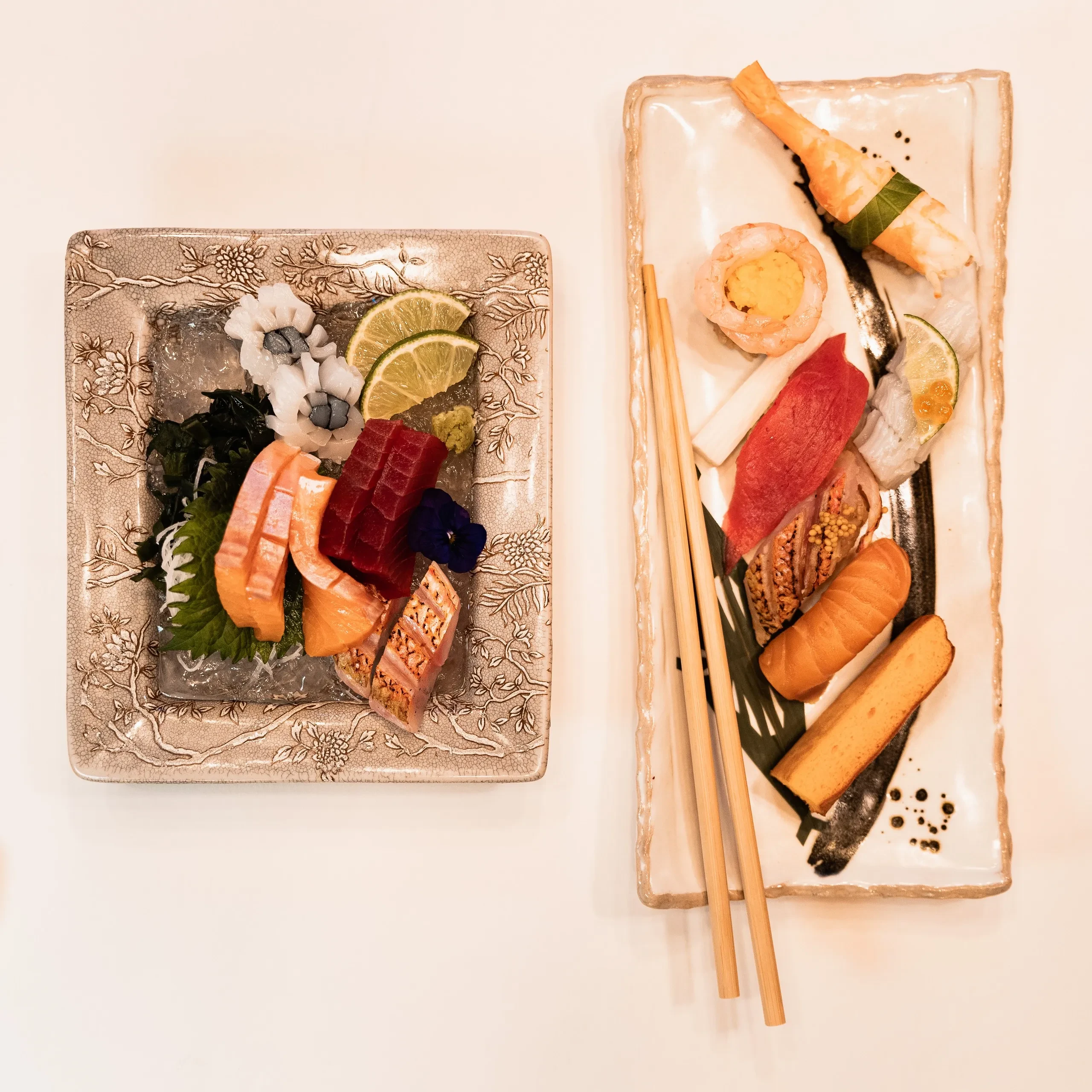 Assortiment de sushis et sashimis sur plats décorés.