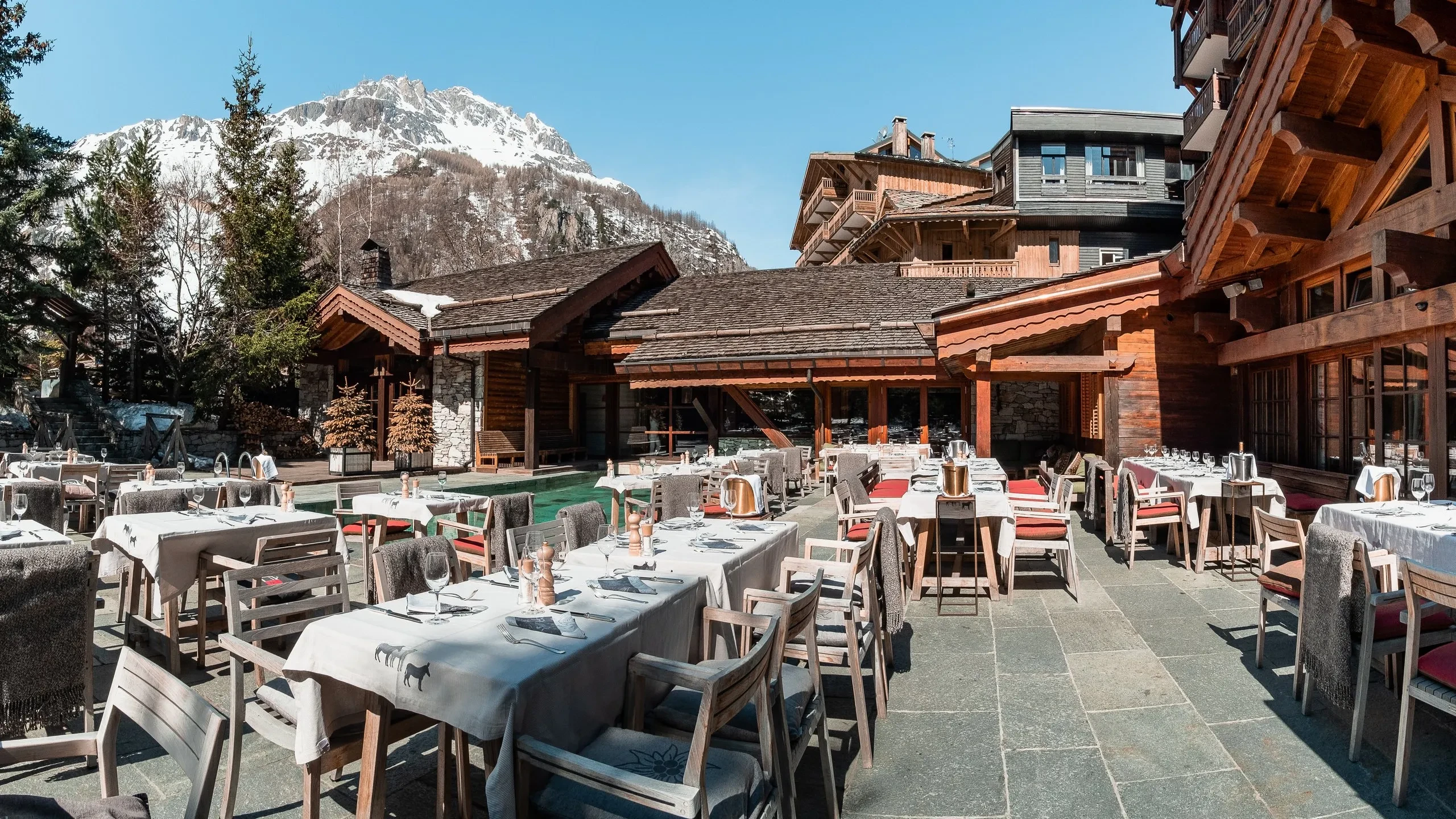 Terrasse de restaurant en montagne enneigée.