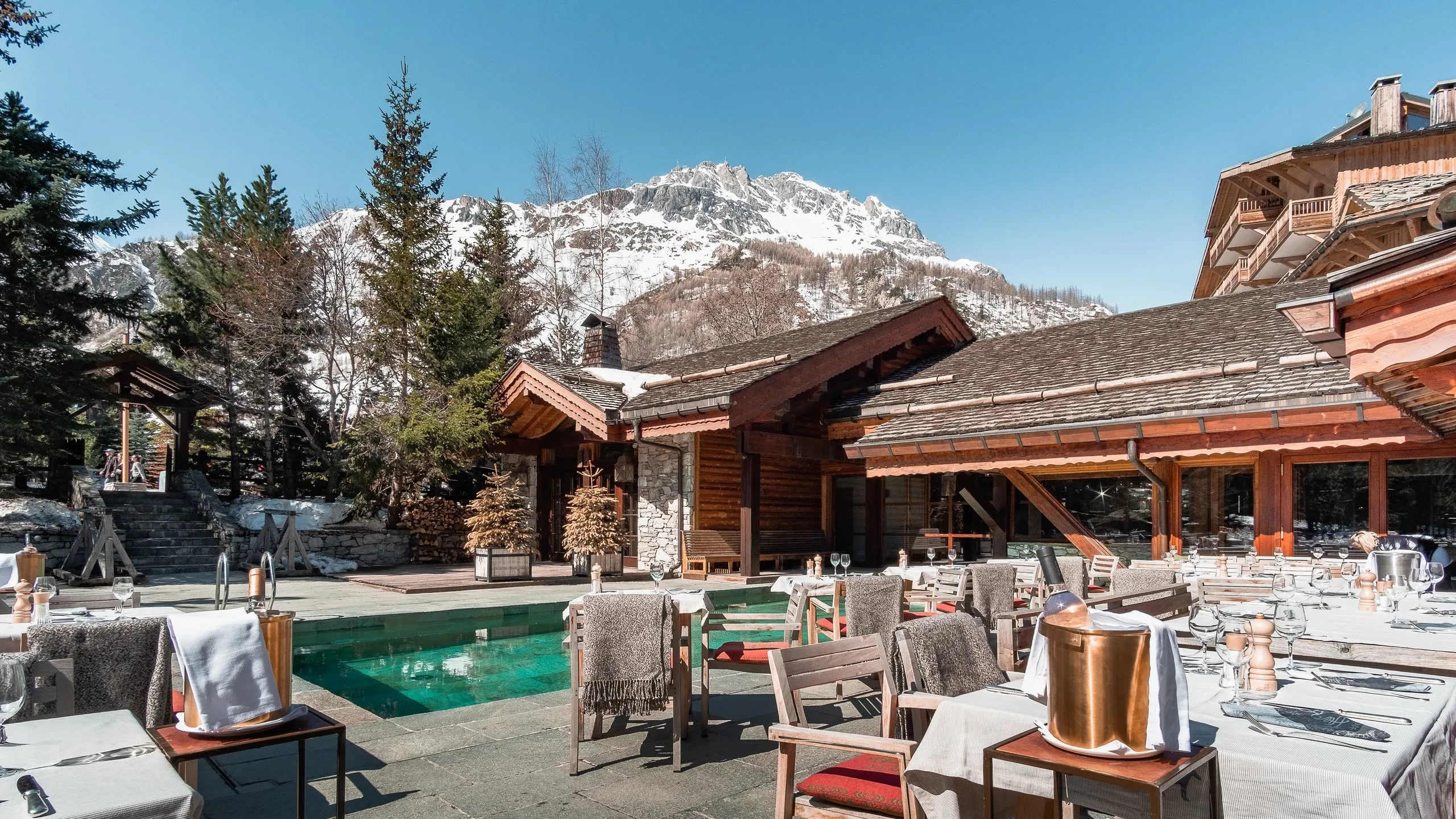 Terrasse de restaurant avec vue sur montagne enneigée.