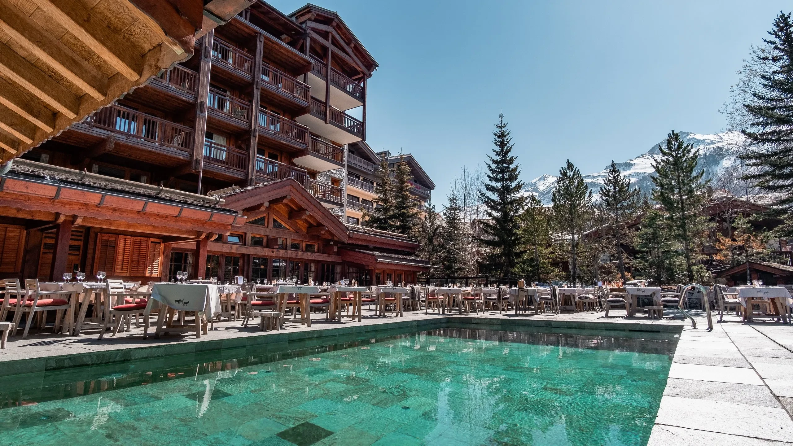 Hôtel alpin avec terrasse et piscine extérieure.