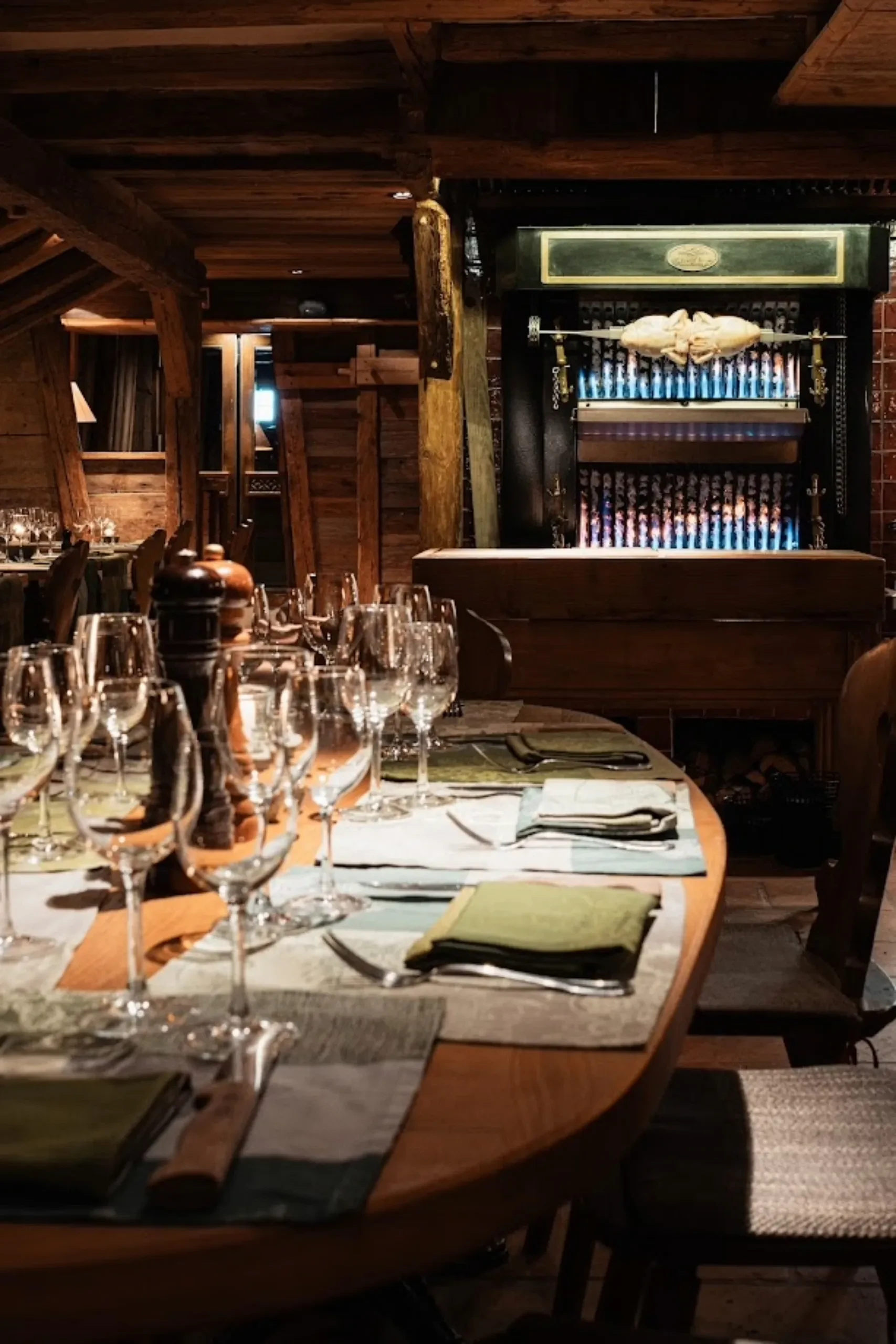 Restaurant rustique avec table et rôtissoire visible.